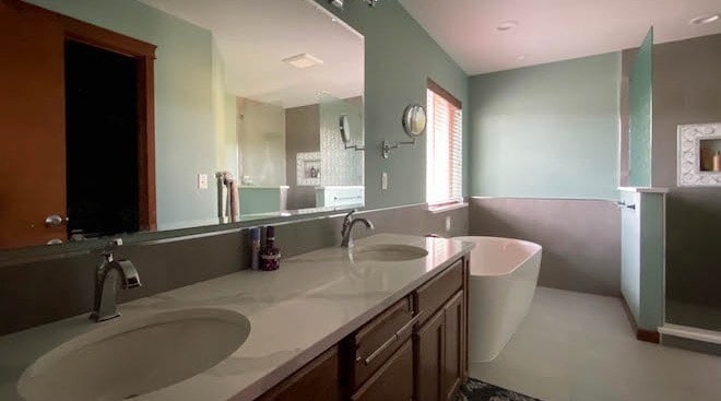 Bathroom, contertop, sinks, mirror, window, tub, shower.